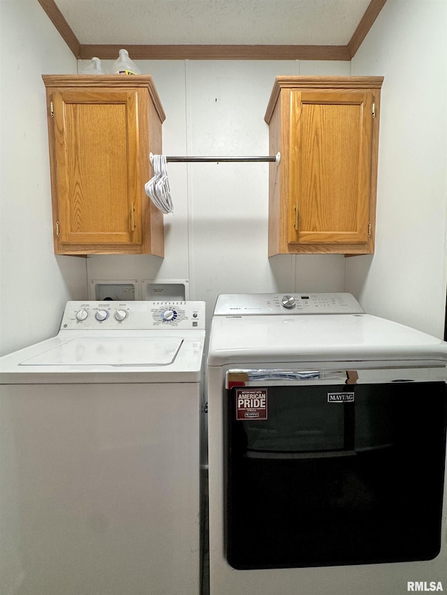 laundry room featuring separate washer and dryer, crown molding, and cabinets