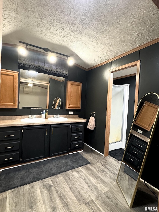 bathroom with hardwood / wood-style flooring, a textured ceiling, and rail lighting