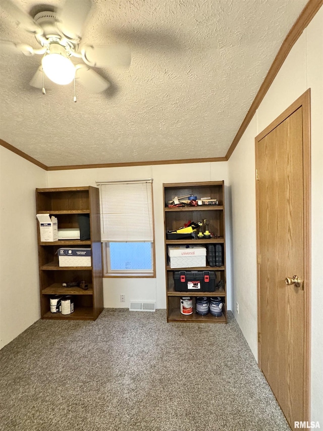 unfurnished bedroom featuring a textured ceiling, carpet floors, ceiling fan, and crown molding