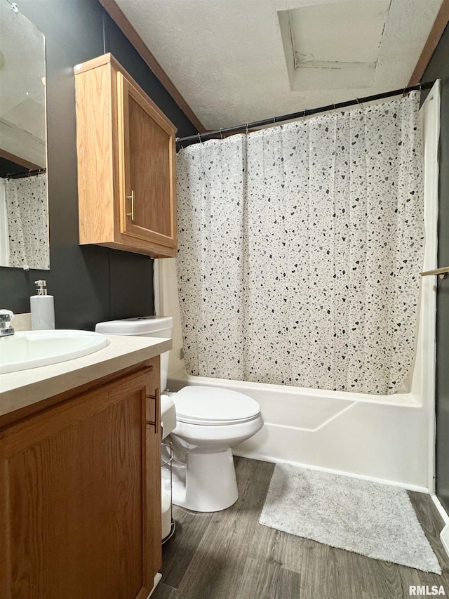 full bathroom with vanity, a textured ceiling, shower / bath combo with shower curtain, wood-type flooring, and toilet