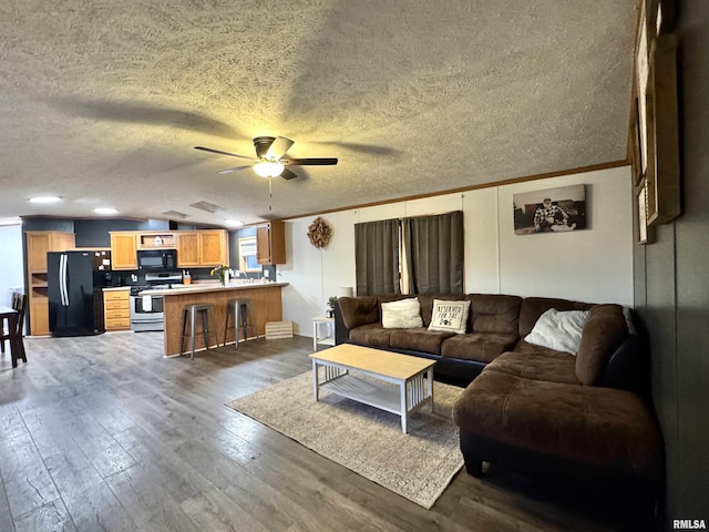 living room featuring dark hardwood / wood-style flooring, a textured ceiling, ceiling fan, and crown molding