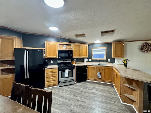 kitchen featuring light wood-type flooring, a textured ceiling, vaulted ceiling, crown molding, and black appliances