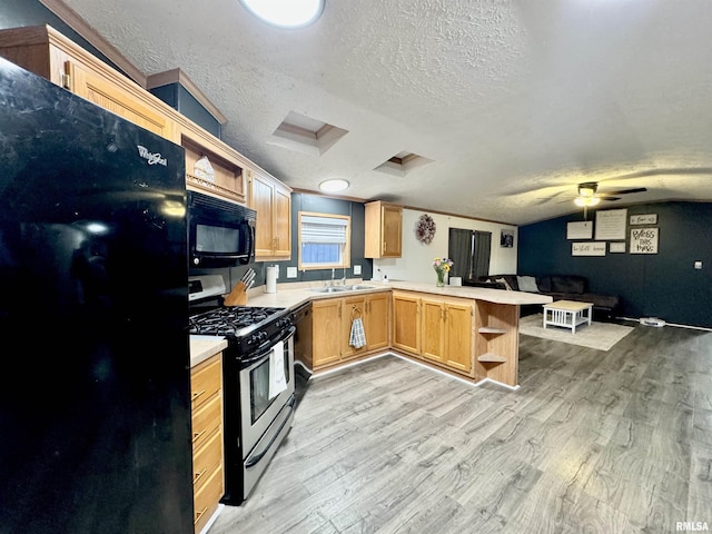 kitchen with kitchen peninsula, a textured ceiling, sink, black appliances, and light hardwood / wood-style floors