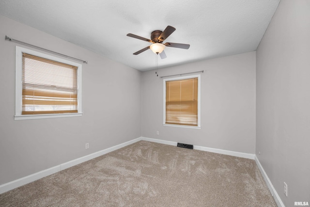 spare room with ceiling fan, carpet floors, and a textured ceiling