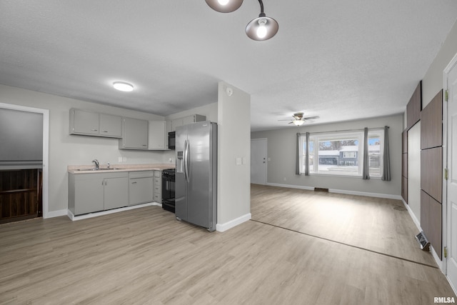 kitchen featuring black appliances, sink, ceiling fan, gray cabinets, and light wood-type flooring