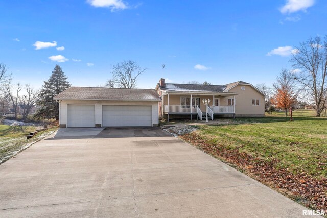 view of front of property with a porch, a garage, and a front lawn