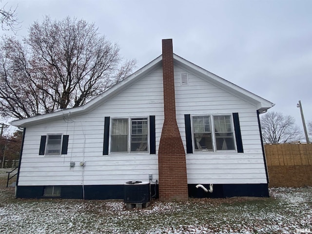 snow covered back of property with central air condition unit