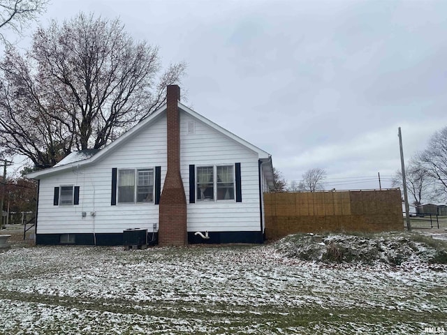 snow covered back of property with cooling unit