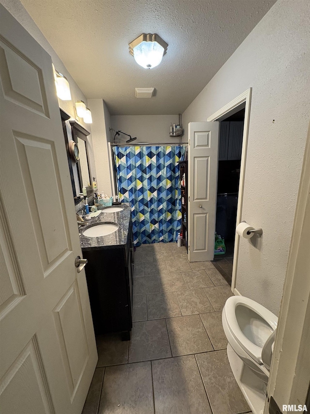 bathroom with vanity, toilet, a textured ceiling, and a shower with shower curtain