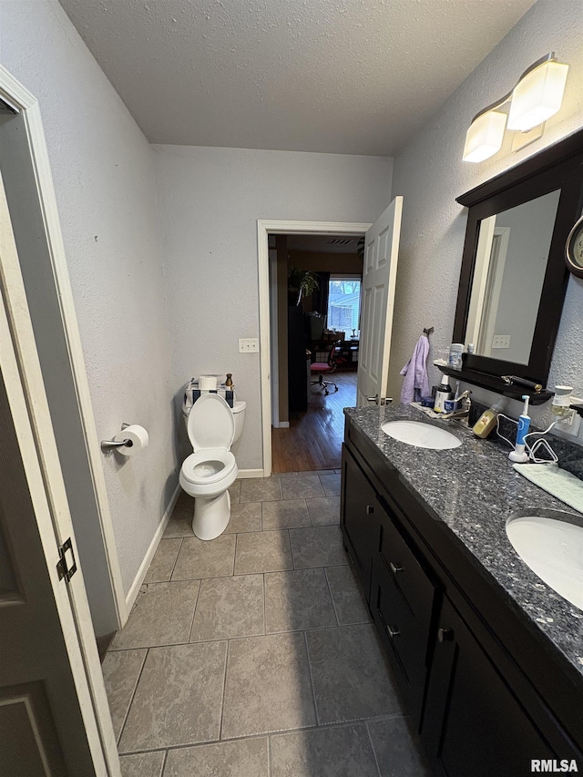 bathroom featuring vanity, a textured ceiling, and toilet