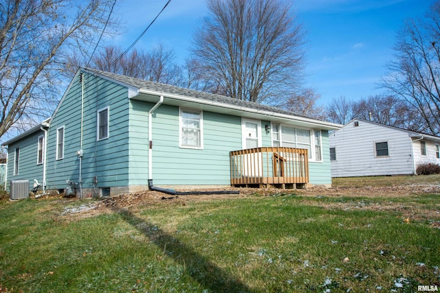 back of property with central AC unit, a deck, and a lawn