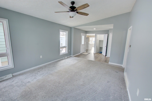 unfurnished bedroom with visible vents, baseboards, lofted ceiling, and carpet