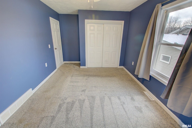 unfurnished bedroom featuring a closet, visible vents, carpet flooring, and baseboards