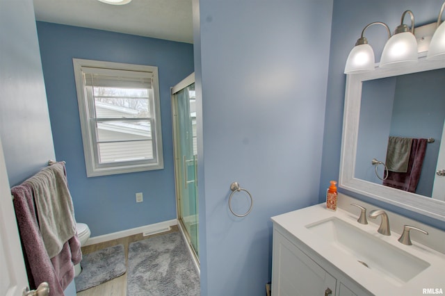 full bathroom featuring baseboards, a stall shower, and vanity