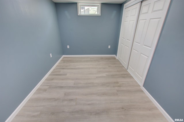 below grade area with light wood-style floors and baseboards