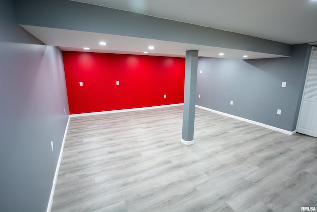 finished below grade area featuring recessed lighting, baseboards, wood finished floors, and an accent wall