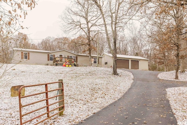 view of front of property featuring an outbuilding, a garage, and a deck