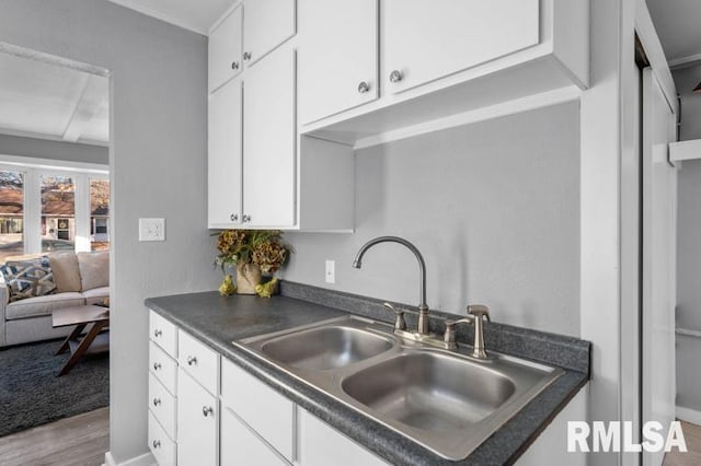 kitchen featuring white cabinets, sink, and light hardwood / wood-style floors