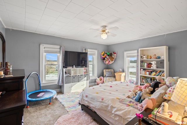 carpeted bedroom featuring ceiling fan and multiple windows