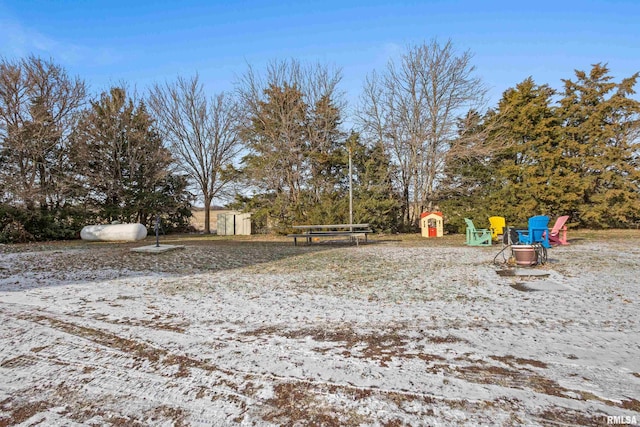 yard layered in snow with a shed