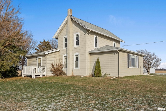 back of property with a deck and a yard