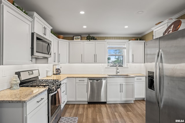 kitchen featuring crown molding, white cabinetry, sink, and appliances with stainless steel finishes