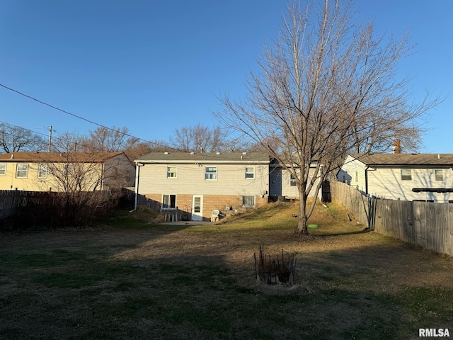 back of house with a yard and central air condition unit