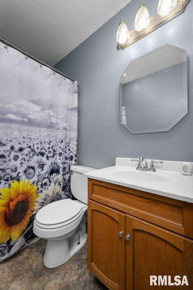 bathroom featuring tile patterned floors, vanity, a textured ceiling, and toilet