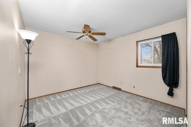 carpeted spare room with ceiling fan and a textured ceiling