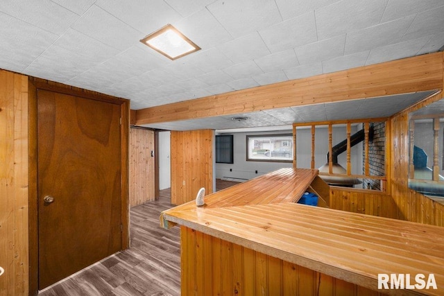 bar featuring hardwood / wood-style flooring and wooden walls