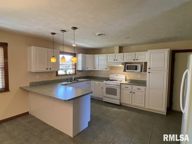 kitchen featuring sink, kitchen peninsula, decorative light fixtures, white appliances, and white cabinets