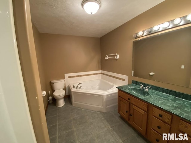 bathroom featuring a tub to relax in, tile patterned floors, vanity, a textured ceiling, and toilet