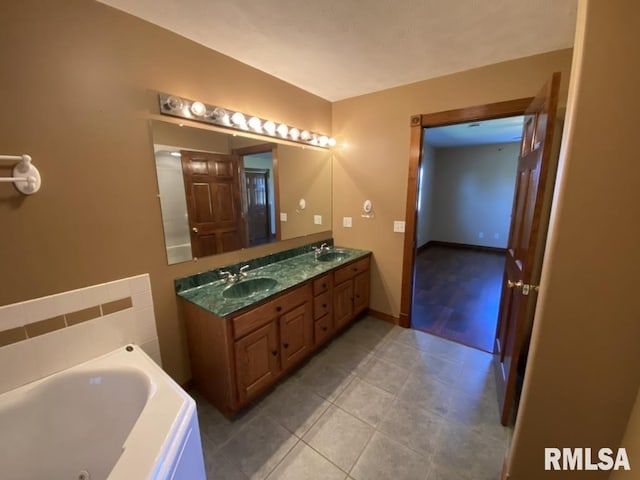 bathroom featuring tile patterned flooring, vanity, and a tub