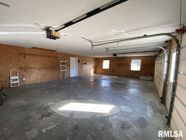 garage with wooden walls and a garage door opener