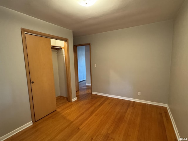 unfurnished bedroom featuring light hardwood / wood-style floors and a closet