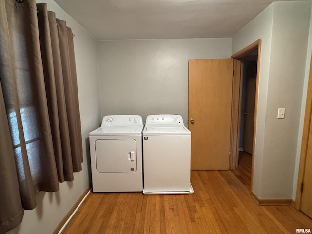 laundry area featuring washing machine and dryer and light hardwood / wood-style floors