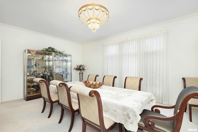 dining room with light colored carpet, crown molding, and an inviting chandelier