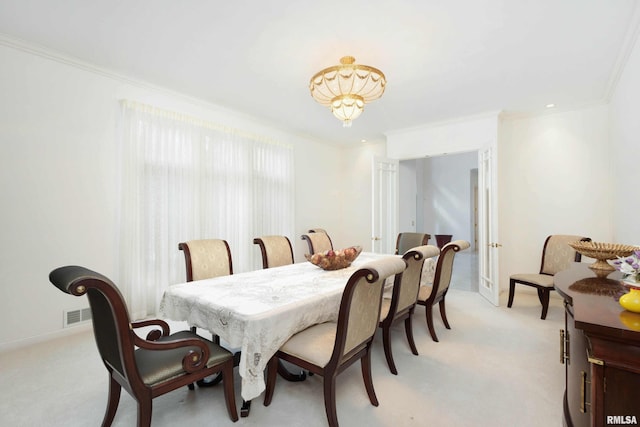 dining room featuring light colored carpet and ornamental molding