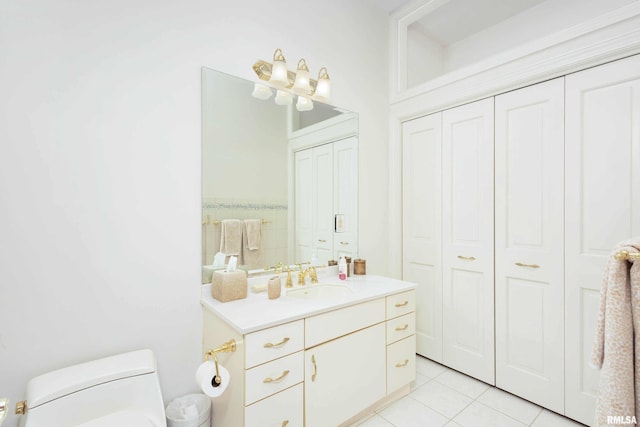 bathroom with toilet, vanity, and tile patterned floors