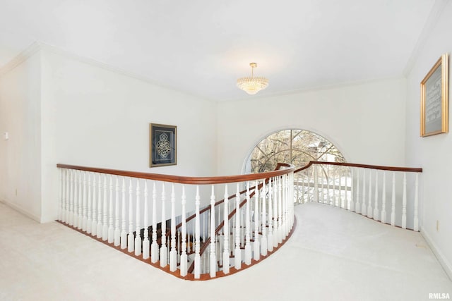 hallway with carpet floors, crown molding, and a notable chandelier