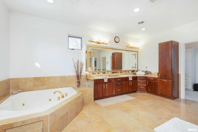 bathroom with tiled tub and vanity