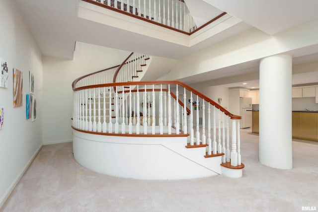 stairs featuring a high ceiling and carpet floors