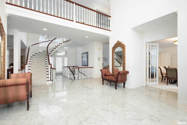 entryway featuring a towering ceiling and ornamental molding