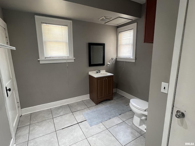 bathroom with toilet, vanity, baseboards, and tile patterned floors