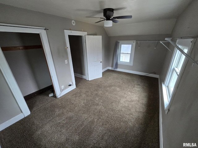 unfurnished bedroom featuring lofted ceiling, ceiling fan, baseboards, and carpet flooring