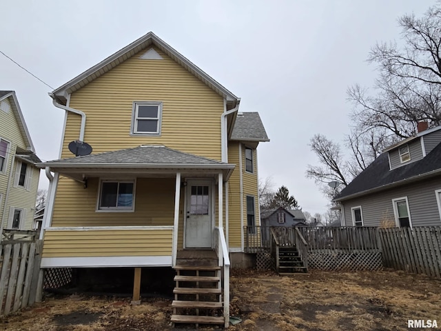 back of property featuring a shingled roof, fence, and a wooden deck