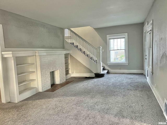 unfurnished living room featuring built in features, carpet floors, and a fireplace