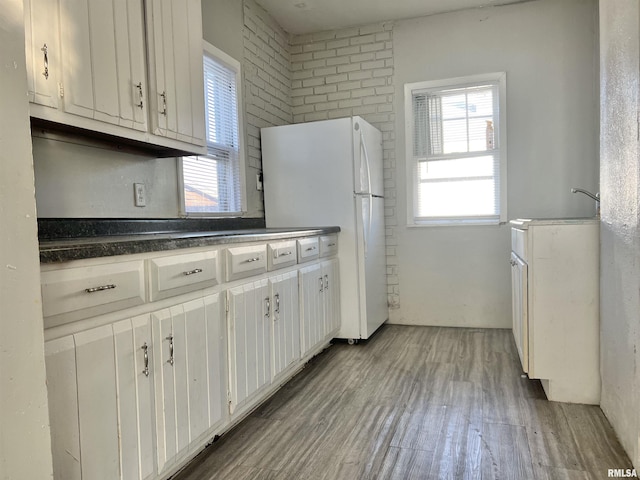 kitchen featuring light hardwood / wood-style floors, white cabinetry, and white fridge