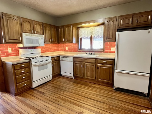 1812 E 1650th St, Paloma, IL 62359 - kitchen with light wood-type flooring, white appliances, sink, and tasteful backsplash