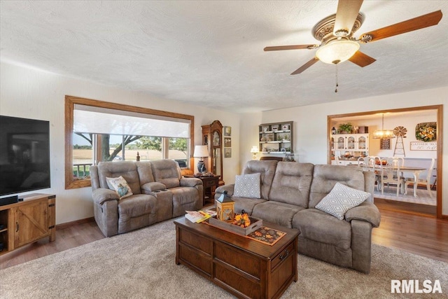 living room with a textured ceiling, light hardwood / wood-style floors, and ceiling fan